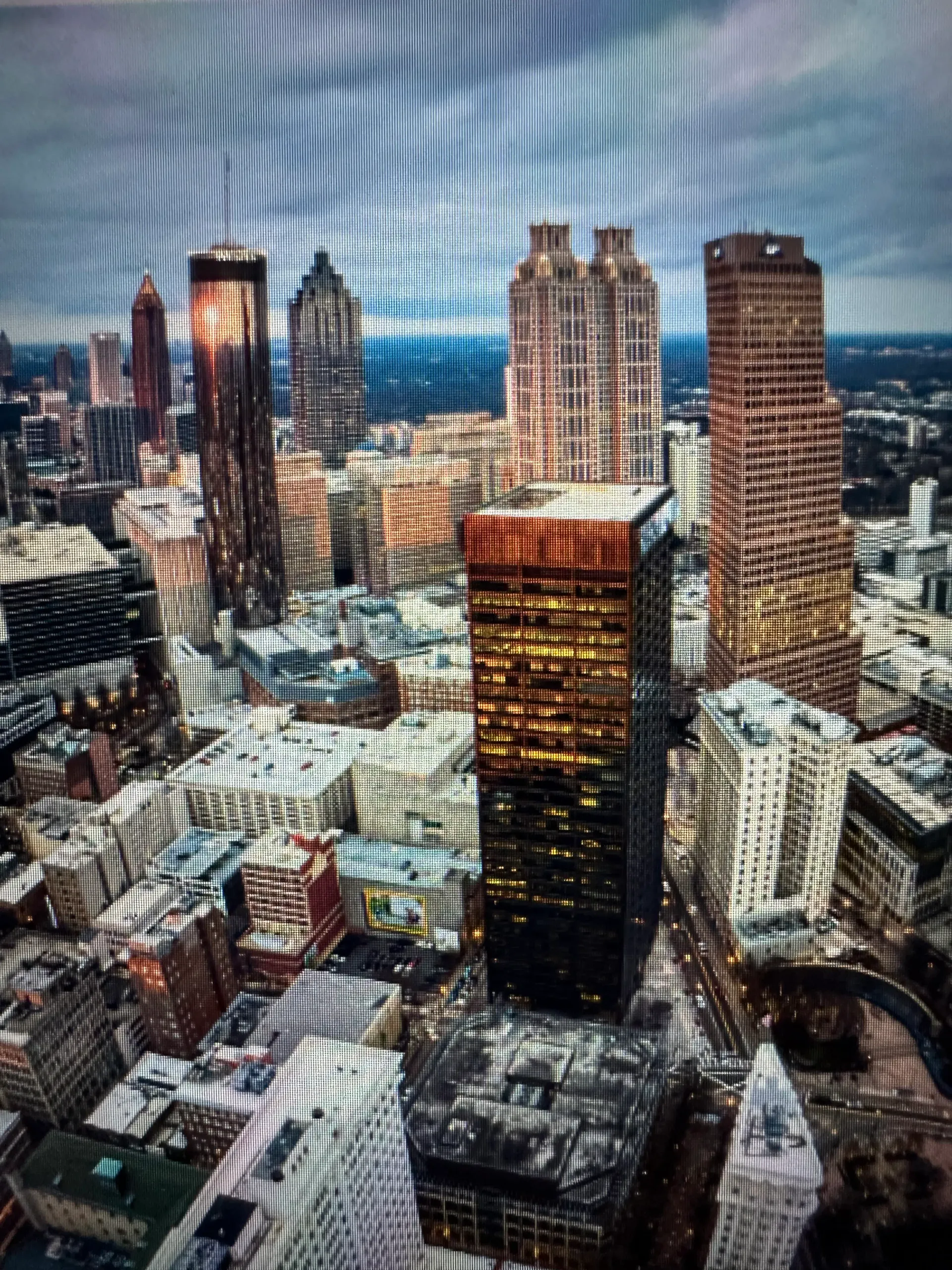 Aerial view of downtown Atlanta, Georgia, with high-rise buildings beneath a cloudy sky.